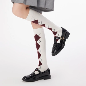 Detail of argyle knee-high socks in white and red paired with Mary Jane shoes