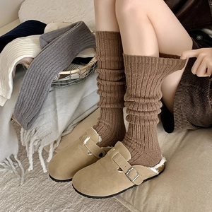 Macro view of ribbed knit calf socks texture with fleece-lined suede mule slippers
