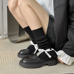 Lolita style black knit leg warmers featuring contrasting white satin bows for women
