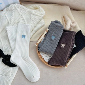 Détail de la broderie nœud doux sur des chaussettes en maille épaisse de diverses couleurs