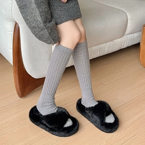 Thick black plush cross-band slippers with warm grey ribbed calf socks for winter comfort