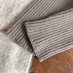 Close-up of taupe ribbed knit leg warmer cuff featuring premium wool-like texture