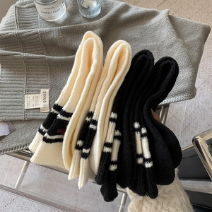 Detailed knit texture of thick wool socks with classic stripes and bow accent