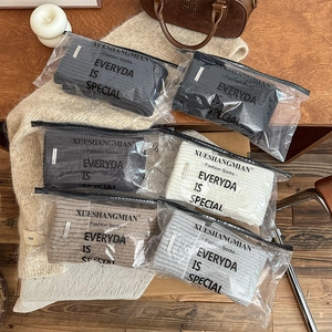 Detail view of multi-color thick knit leg warmers in independent zipper packaging