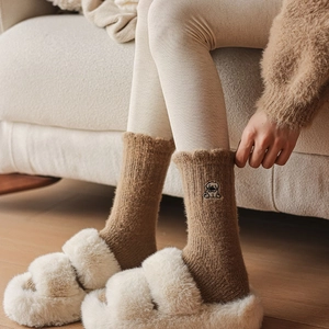Detail of warm brown knit socks with cute puppy embroidery and wavy ruffled edges