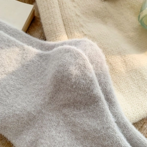Dettaglio del tessuto a maglia felpata in grigio e beige per calze termiche invernali