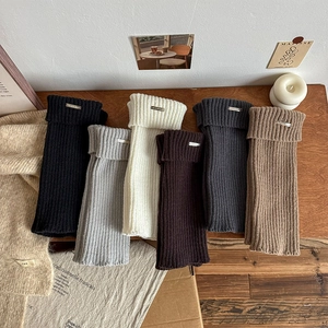 Macro detail of ribbed knit leg warmers in six colors with metallic label accents