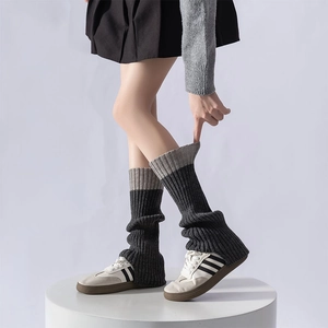 Dettaglio degli scaldamuscoli in maglia grigio scuro con bordo e trama grigio chiaro