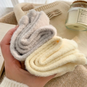Dettaglio di calze di peluche spesse con texture morbida nei colori grigio e panna