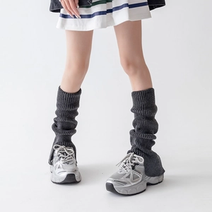 Macro detail of dark grey ribbed knit leg warmers with thick texture and elastic hem
