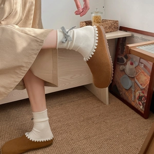 Brown felt house slippers with wavy trim shown with stylish grey bow crew socks