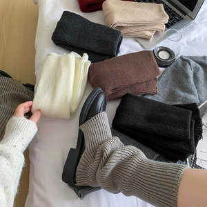Close-up of thick knit leg warmers showing ribbed texture and various autumn colors