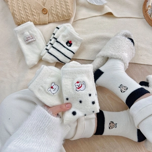 Detailed view of warm winter socks with cute animal embroidery and fuzzy striped textures