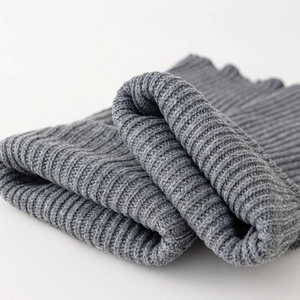 Detailed macro view of the grey ribbed knit texture and thick winter fabric of the leg warmer