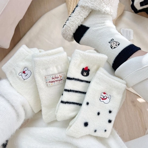 Macro detail of cute dog embroidery and stripes on thickened white velvet winter socks