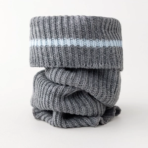 Macro detail of thick grey ribbed knit leg warmer featuring a blue accent stripe