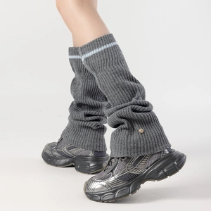 Detailed knit texture of dark grey ribbed leg warmers with blue stripe and gold metal logo