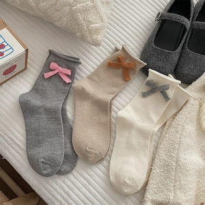 Three pairs of sweet bow-accented crew socks in grey, beige, and cream with Mary Janes