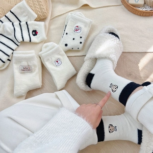 Close-up of warm winter socks with cute dog embroidery and cozy coral fleece texture