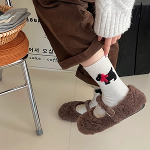 Detail of white wool socks with embroidered dog pattern and red 3D bow decoration