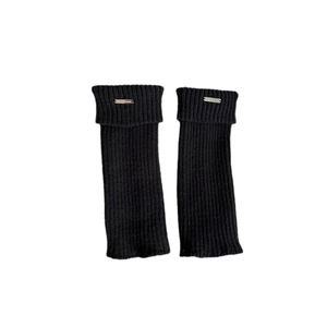 Thick knit black leg warmers with ribbed texture and decorative metal label for winter