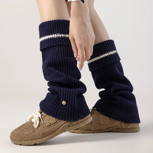 Detail of navy knit leg warmers with white stripes and metallic buckle on high-elastic fabric