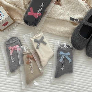 Detail of knit bow socks in multi-color options with premium zipper bag packaging