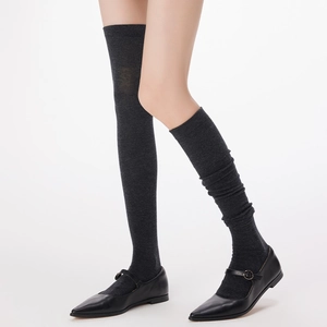 Thigh-high charcoal grey knit socks for women paired with black Mary Jane shoes