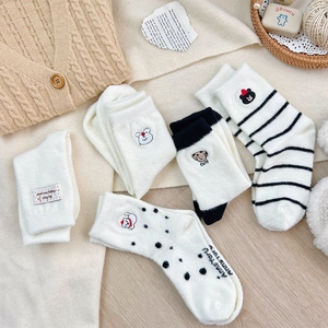 Detail of five pairs of thick winter socks with cute animal embroidery and stripe patterns