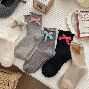 Close-up of knit bow detail and ruffled edge on sweet girl style cotton crew socks