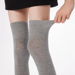 Detail shot of grey thigh-high socks showing high-elasticity knit fabric through stretching