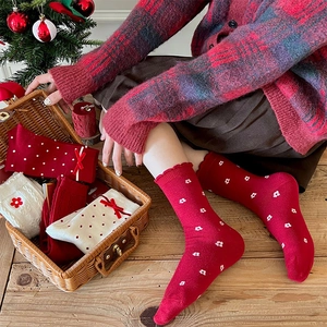 Calze di Natale rosse e bianche con fiocchi e fiori in un cesto regalo accogliente