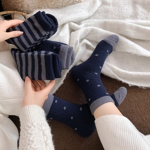 Detail of warm navy blue striped and polka dot plush socks made of soft coral fleece material