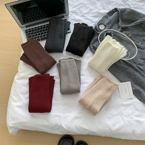 Flat lay of ribbed knit leg warmers in seven earthy colors for autumn and winter