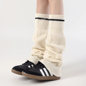 Detail of cream rib-knit leg warmers with black stripe and soft slouchy texture