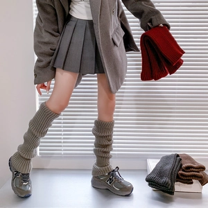 Detailed knit texture of ribbed leg warmers in grey, burgundy, dark grey and coffee brown