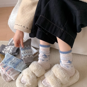 Detailaufnahme dicker Wollsocken mit blauen Berg- und geometrischen Schneemustern
