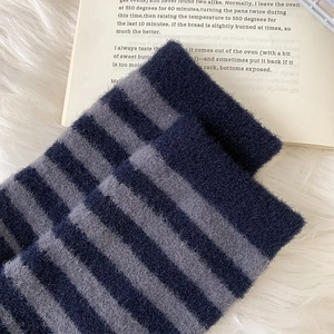 Macro shot of fluffy striped knit socks texture with deep blue and grey plush fibers