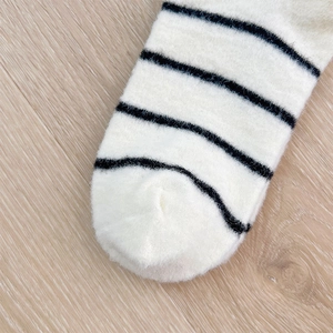 Close-up of the reinforced toe seam and fuzzy striped texture on warm winter socks