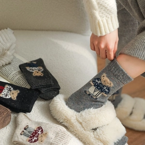 Close-up of thick winter wool socks featuring cute bear patterns and knitted texture