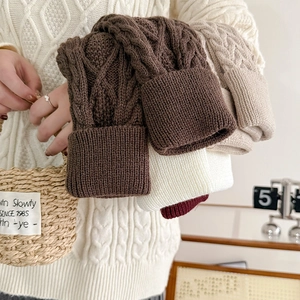 Gros plan sur la maille torsadée et le revers plié de ces bonnets d'hiver chauds