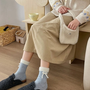 Detail of light blue knit socks with white faux fur cuffs and a sweet bow decoration