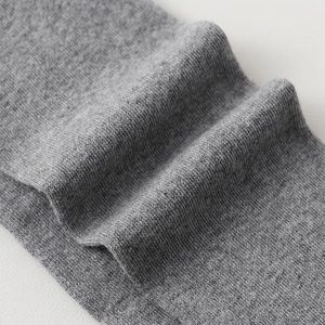 Close-up of grey knitted over-the-knee socks showing fine texture and elastic fabric