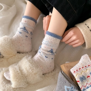 Detail von Wollsocken mit blauen Wellenmustern und roten Punkten im Haus