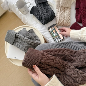 Détails de la maille torsadée d'un ensemble de jambières en laine aux tons rétro