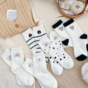 Detail of soft winter socks with cute animal embroidery and festive Happy New Year labels
