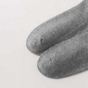 Close-up of grey over-the-knee socks showing the seamless toe and fine knit texture