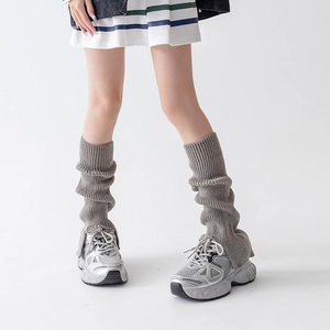 Detail of light grey ribbed knit leg warmers showing soft texture and slouchy style