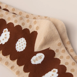 Detailed macro view of non-slip cotton socks showing grip texture and bear embroidery