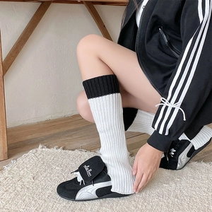 Dettaglio di scaldamuscoli in maglia bianco e nero con trama a coste per la moda invernale